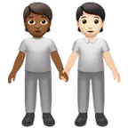 people holding hands: medium-dark skin tone, light skin tone para la plataforma Apple