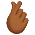 hand with index finger and thumb crossed: medium-dark skin tone per la piattaforma Apple